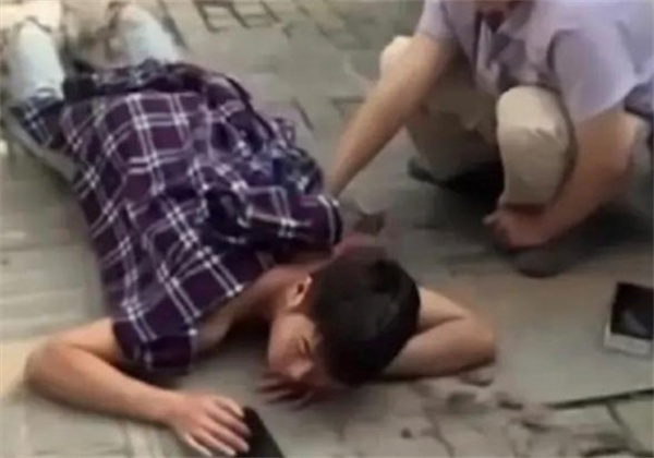 一名男子被捅后趴在地上淡定玩手机