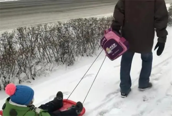 暴雪后家长拉滑雪板接送小孩